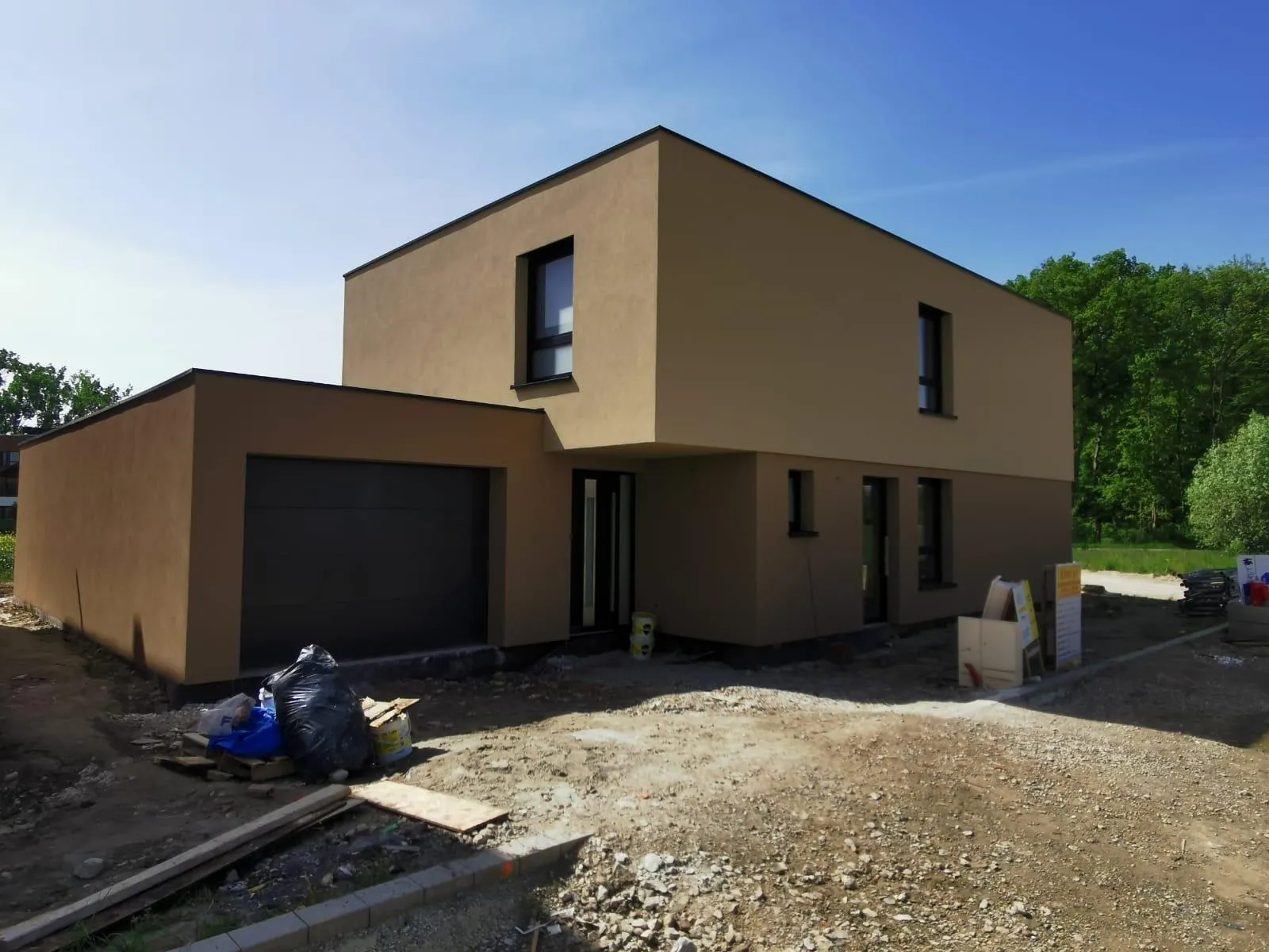 Maison à toit plat avec façade enduite ton sable, en fin de chantier
