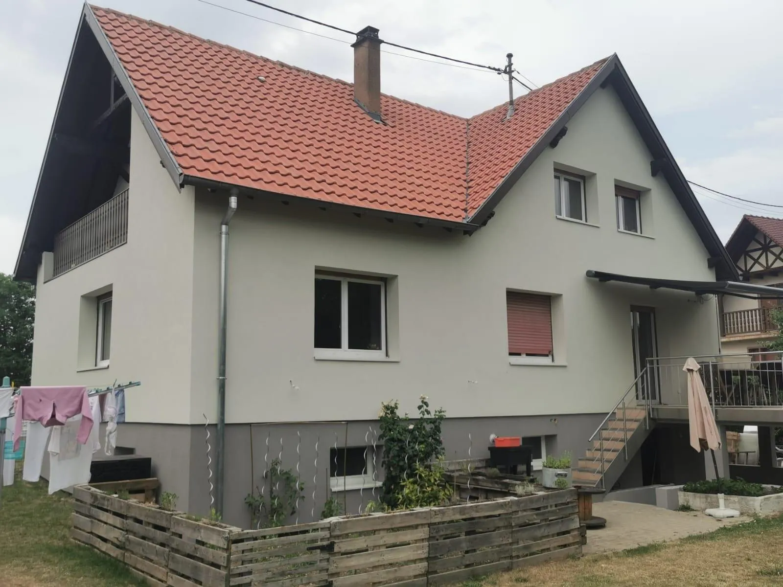 Maison à façade gris clair et soubassement gris foncé, toit de tuiles